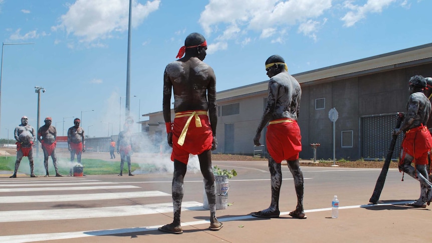 Inidgenous dancers in traditional body paint perform a smoking ceremony to open the new Darwin prison