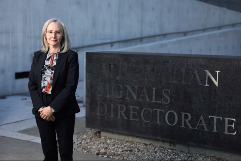 Rachel Noble posing for a photo in front of an Australian Signals Directorate sign