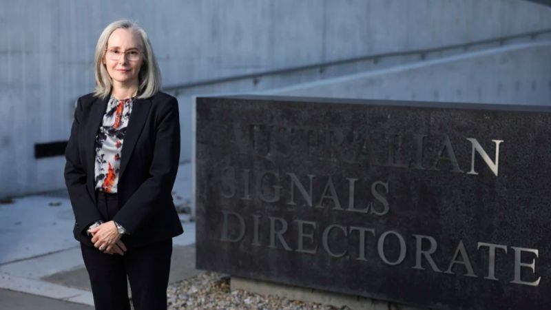 Rachel Noble posing for a photo in front of an Australian Signals Directorate sign