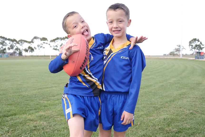 Two boys, wearing blue and yellow uniforms, from the Natimuk United Football Club in Victoria's west