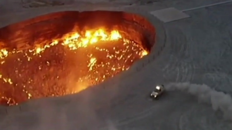The president of Turkmenistan has appeared on state television driving a rally car to a flaming gas crater.