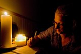 ABC journalist Penny Timms, reports on Cyclone Yasi in Townsville, using just candlelight, pen and paper for the 4am ABC Radio news bulletin.