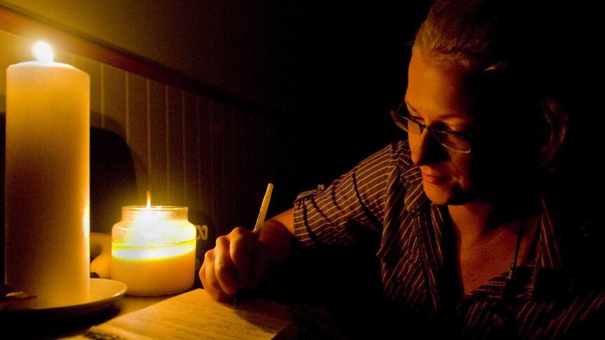 ABC journalist Penny Timms, reports on Cyclone Yasi in Townsville, using just candlelight, pen and paper for the 4am ABC Radio news bulletin.