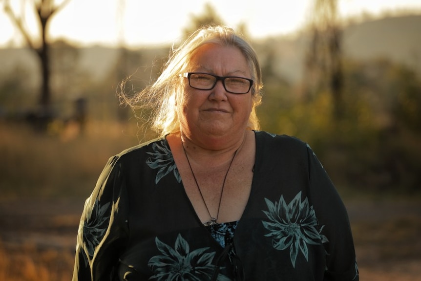 Kristina Walton, a woman with light hair illuminated by evening light, looks at the camera.