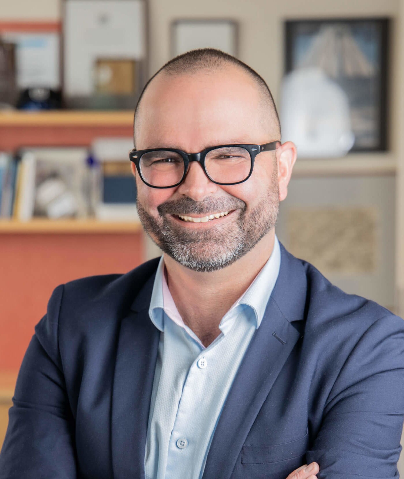 A man in a suit with glasses smiling
