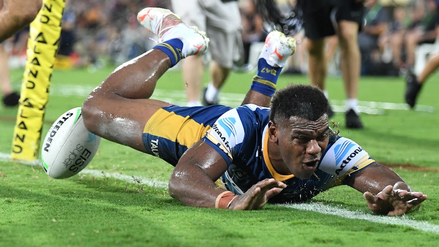 A Parramatta Eels NRL player dives to score a try against Brisbane.