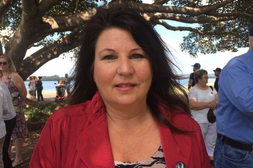 A woman stands at a coastal location.