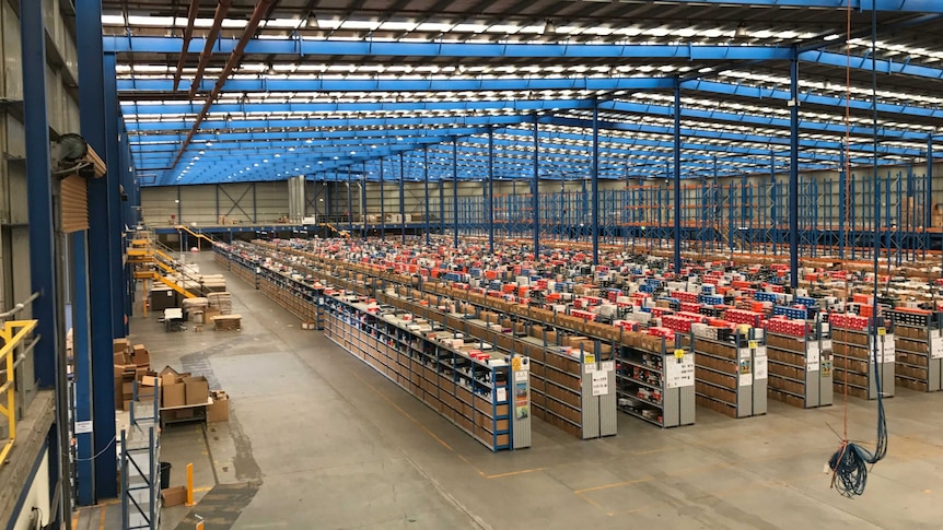 Rows of shelves and stock site in a large warehouse owned by The Iconic.