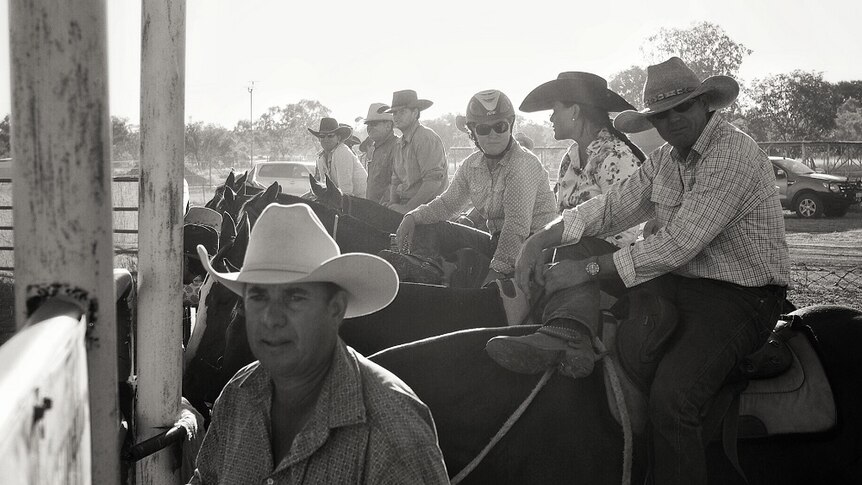 A black and white image of drafters waiting to be called to compete in the Halls Creek Campdraft.