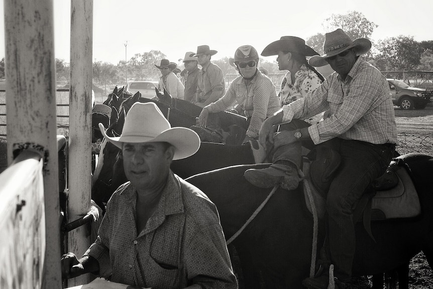 A black and white image of drafters waiting to be called to compete in the Halls Creek Campdraft.