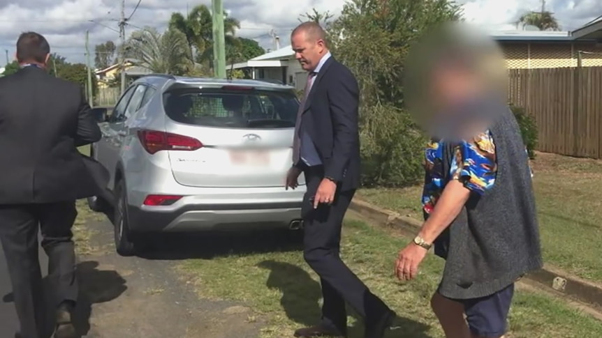 A man being arrested by plain-clothes detectives