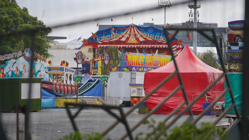 Ekka rides being packed up, image taken through a wire fence.