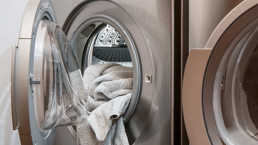 the door of a washing machine is open, showing a dirty towel