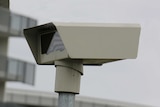 A speed camera in front of a building.