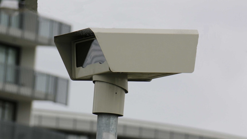 A close-up photograph of a speed camera mounted on a pole.