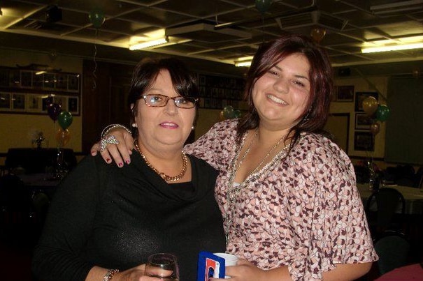 Two women with dark hair smile at the camera