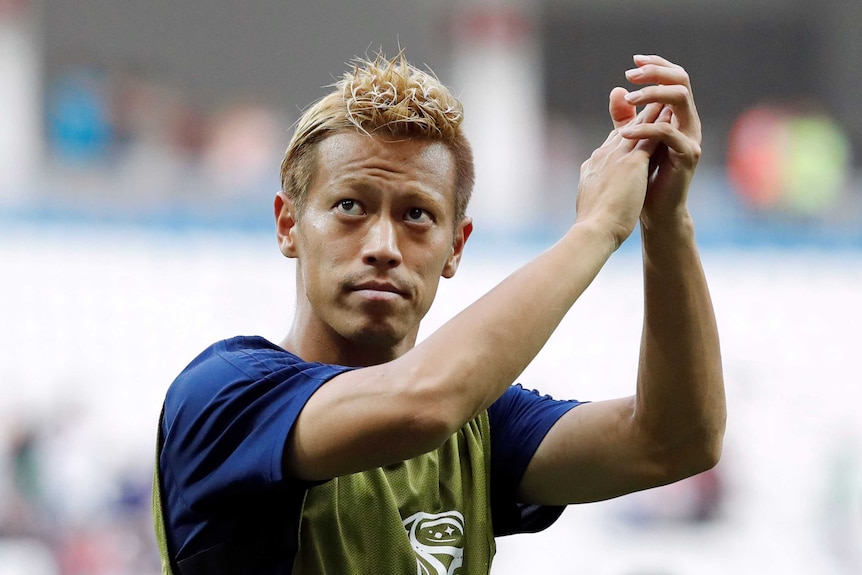 Keisuke Honda applauds fans after a match against Poland