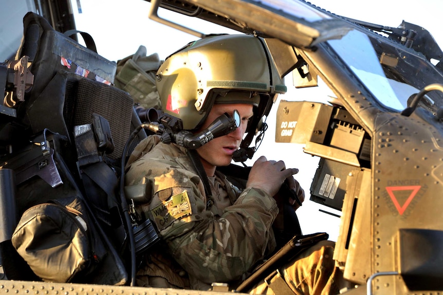 Prince Harry sits in his Apache Helicopter cockpit.