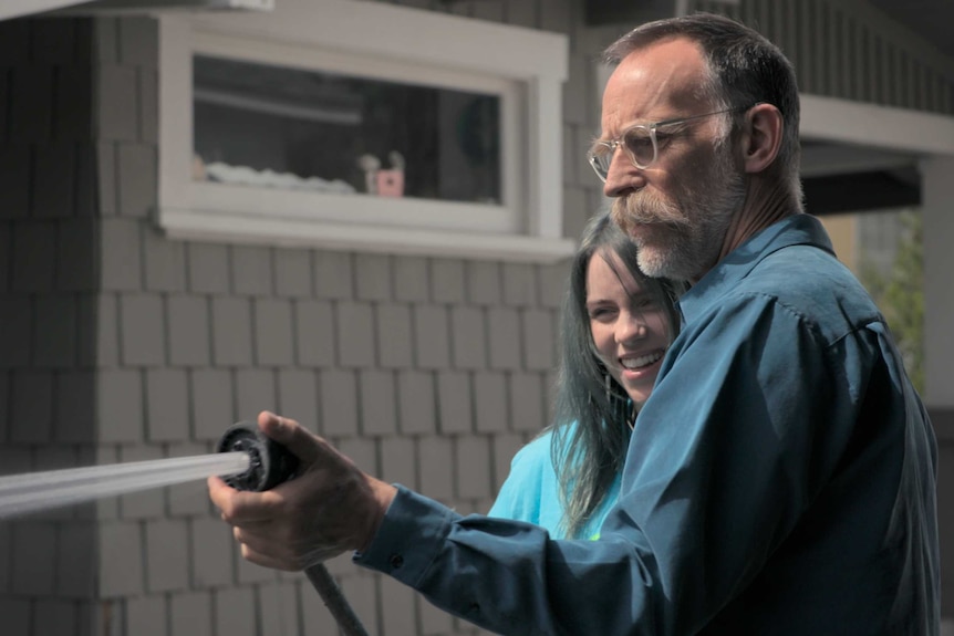 A scene from the documentary Billie Eilish: The World's a Little Blurry with Billie and her father Patrick outside