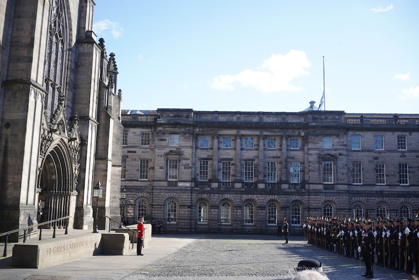 A group of guards wait for King Charles outside a cathedral in Edinburgh