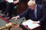 Boris Johnson reaches for the mace inside the House of Commons.