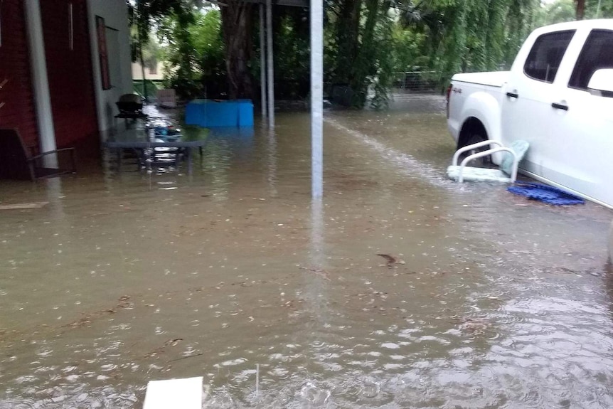 Rain falls at an already flooded home north of Townsville.