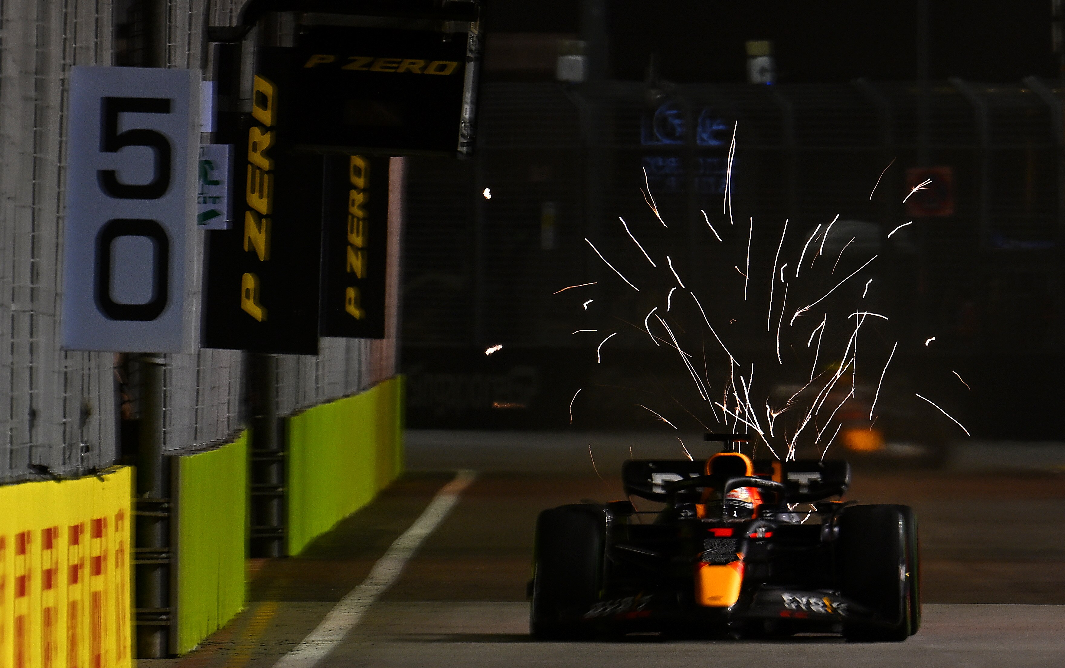 Formula 1 driver Max Verstappen races down a straight in qualifying, as sparks are seen behind his car. 