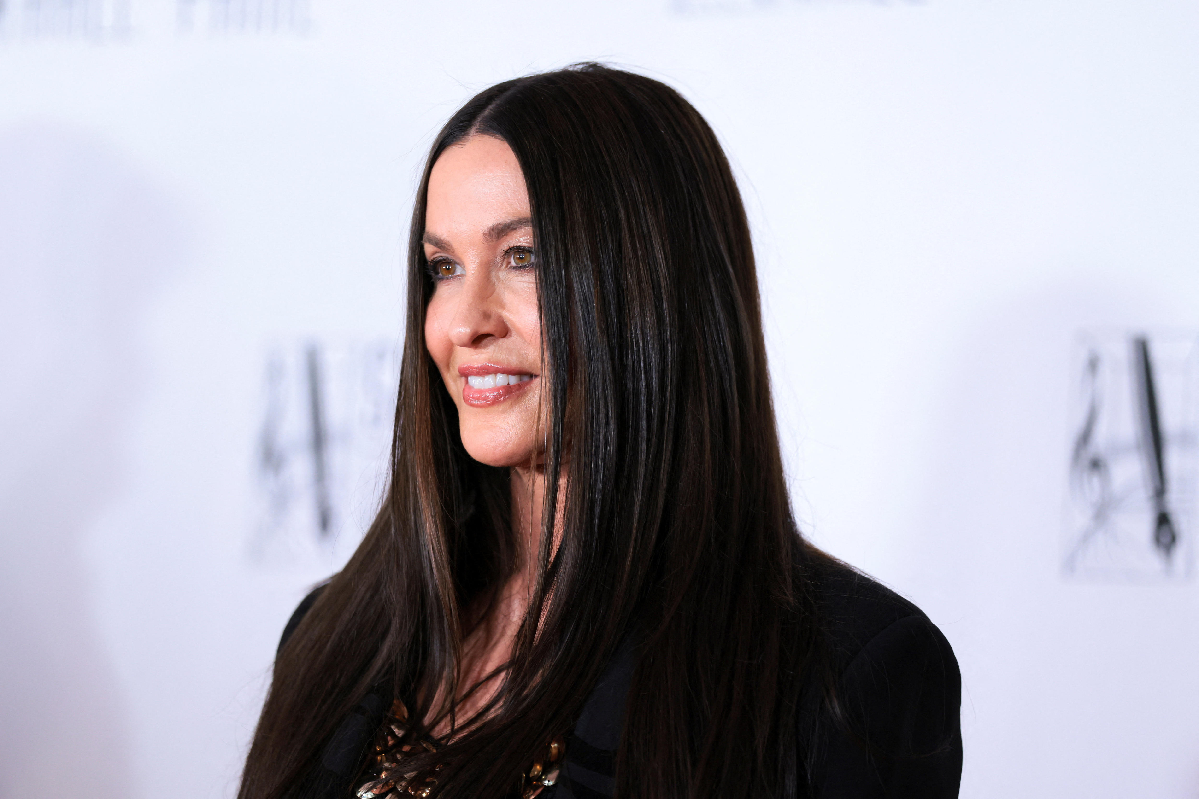 Alanis Morissette side profile looking off into the distance smiling