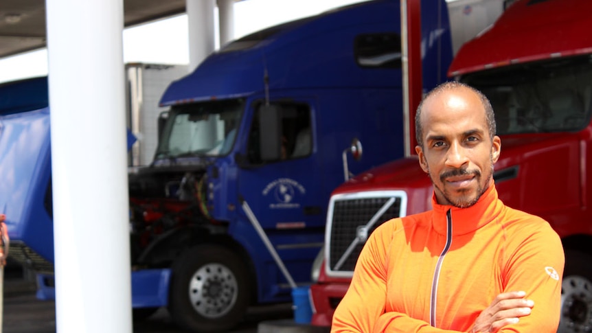 Fitness instructor Siphiwe Baleka standing in front of the trucks he drives