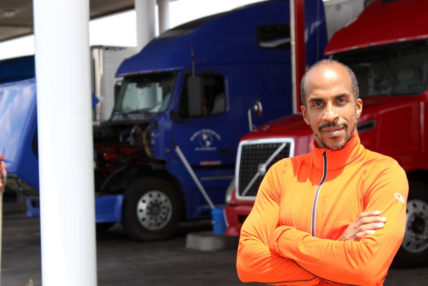 Fitness instructor Siphiwe Baleka standing in front of the trucks he drives