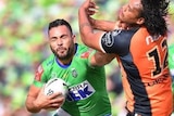 Canberra Raiders forward Ryan James fends off Wests Tigers' Luciano Leilua in their NRL clash.