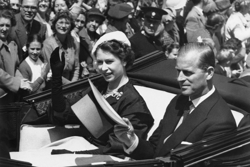 Queen Elizabeth II is driven in an open carriage from the Golden Gates at Ascot in this 1952 photo. Prince Philip is with her.