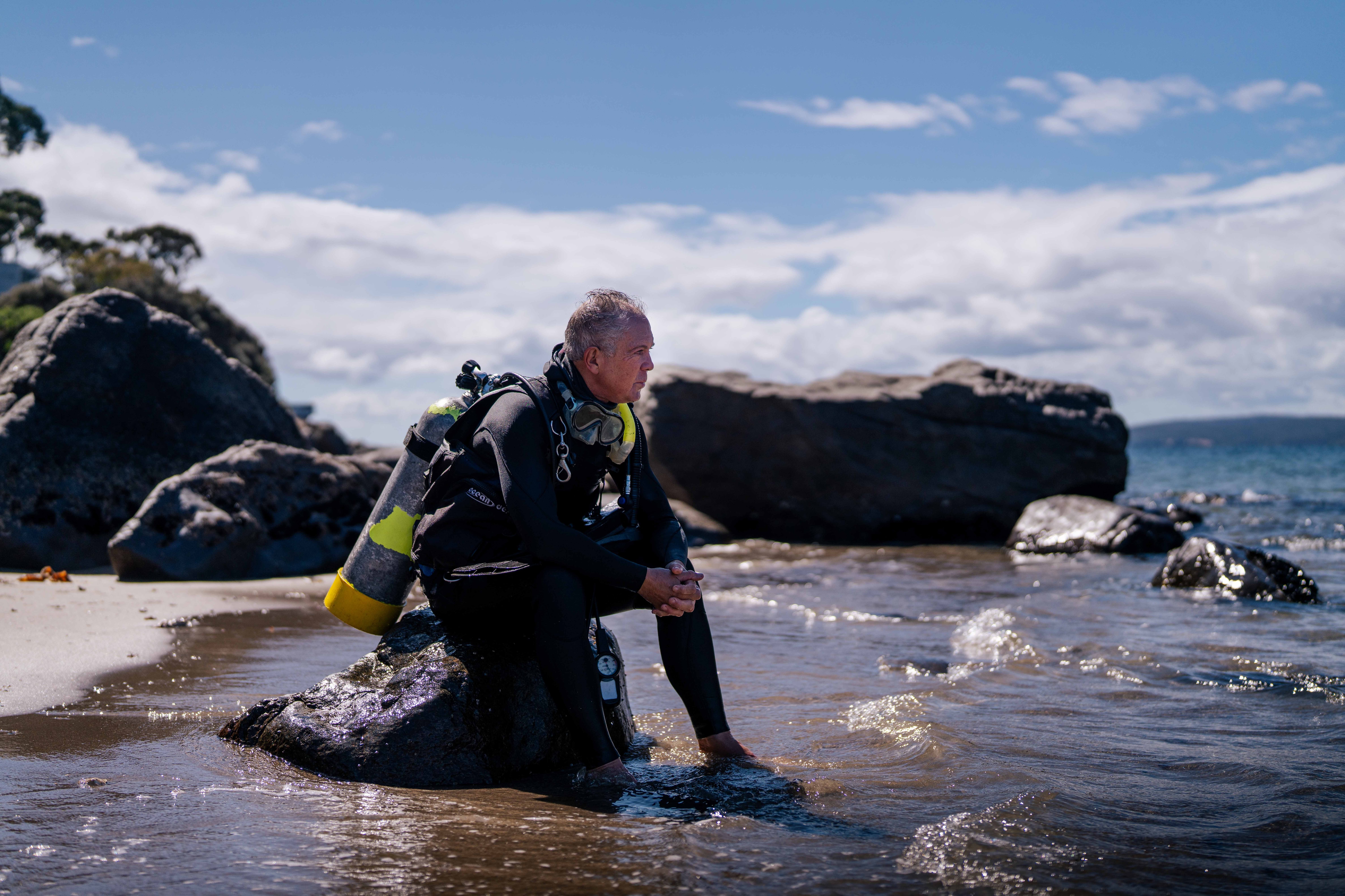 O homem senta-se e reflete na praia.
