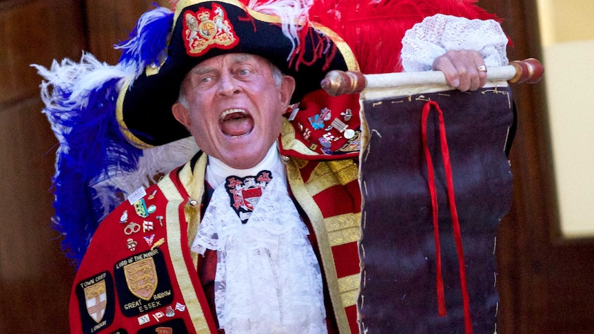 A Town Crier reads an announcement declaring the birth of a baby boy.