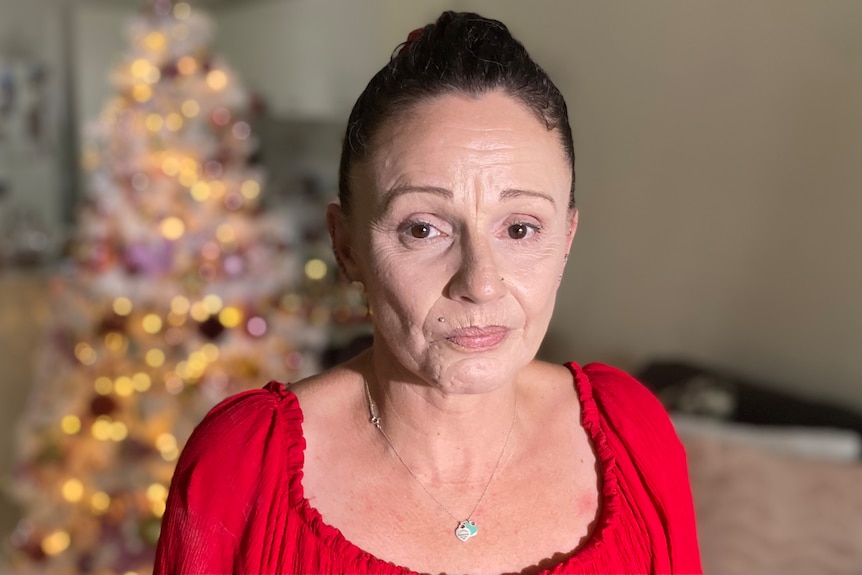 A woman standing in front of christmas decorations in her living room