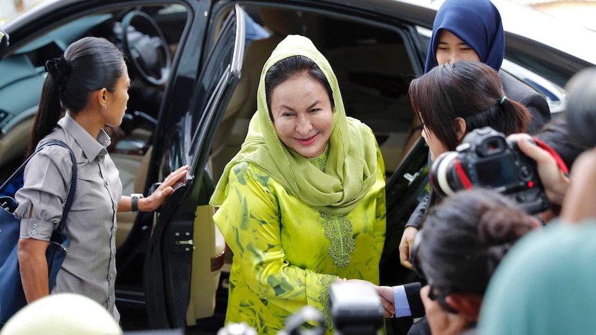 Rosmah Mansor shakes hands with someone as she arrives at the Anti-Corruption Agency.