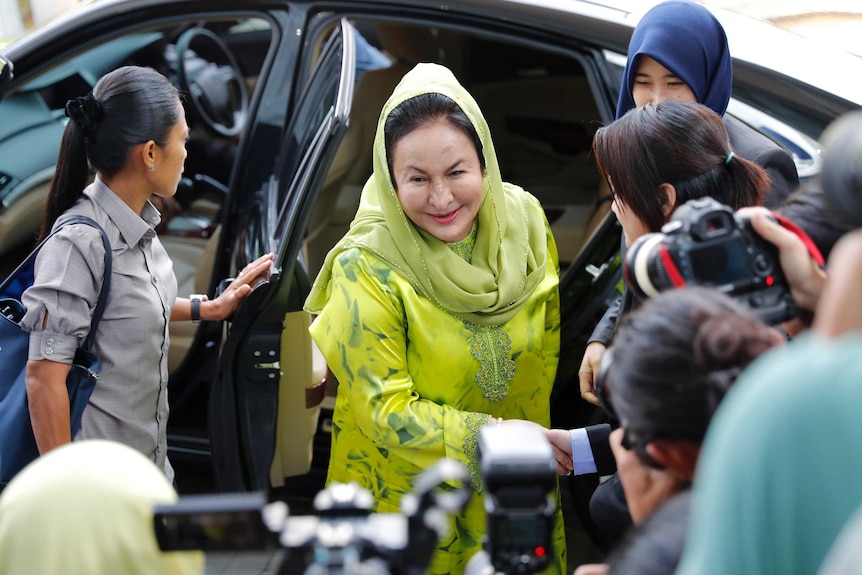 Rosmah Mansor shakes hands with someone as she arrives at the Anti-Corruption Agency.