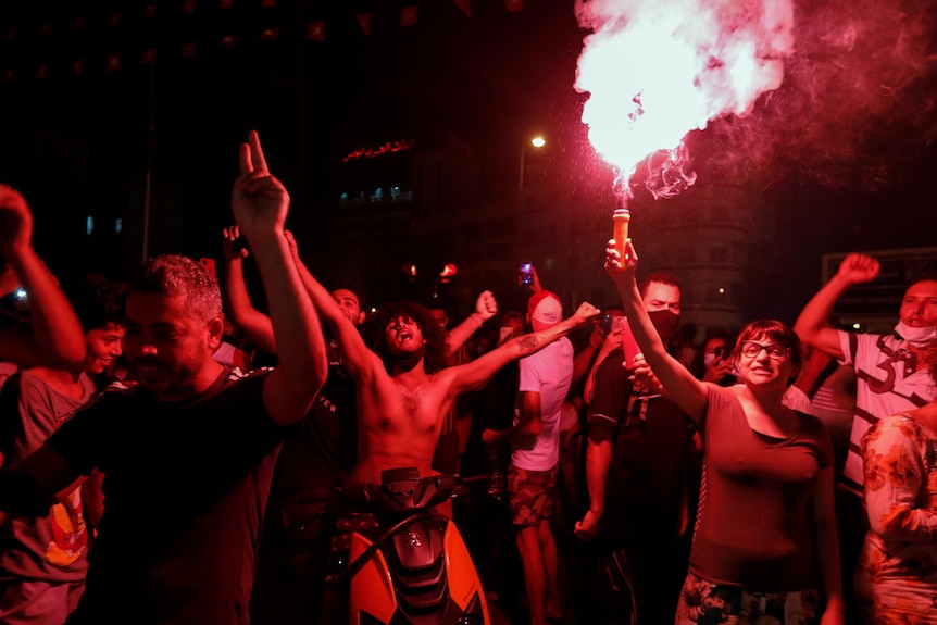 Supporters of Tunisia's President Kais Saied gather on the streets with flares