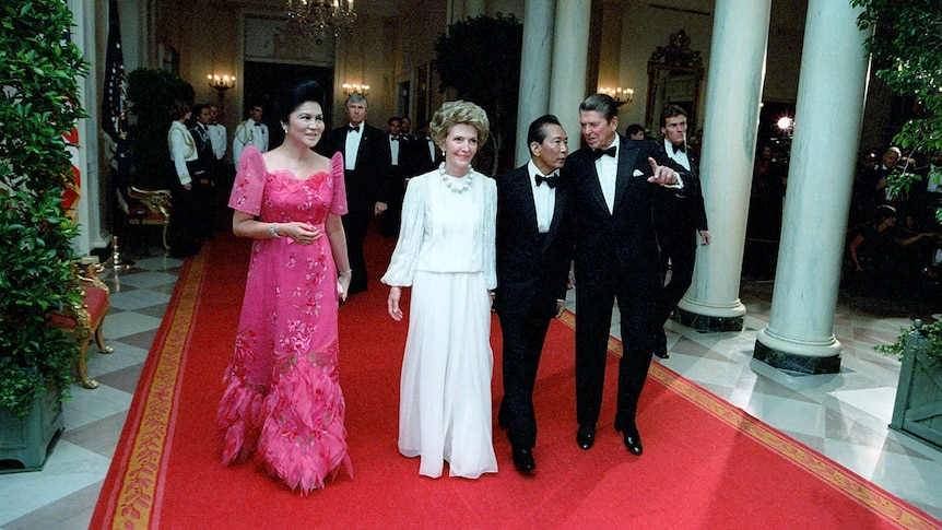 Imelda Marcos in a bright pink ballgown with feathered skirt, Nancy Reagan in a chic white gown, presidents both in tuxedos