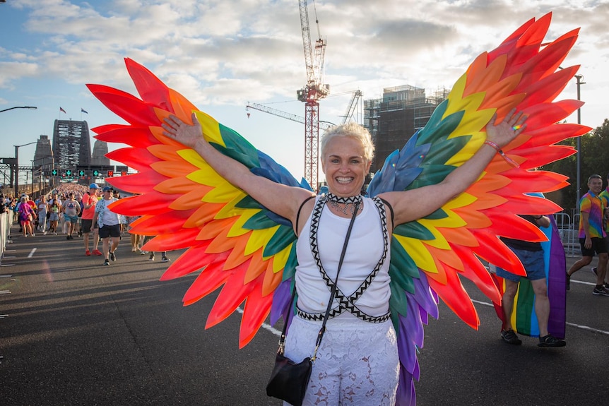 A woman wearing colourful rainbow wings
