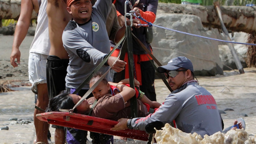 Rescuers evacuate Lenlen Medrano, who had been caught in the floodwaters.