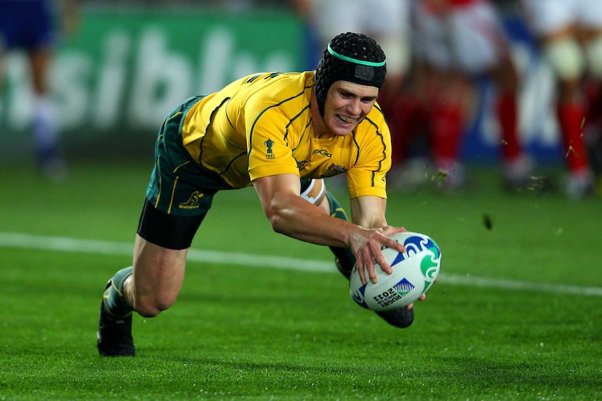 Wallabies man-of-the-match Berrick Barnes dives over for the first try. (Getty: Alex Livesey)