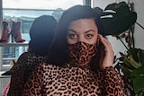 a woman in a leopard print mask and bodysuit