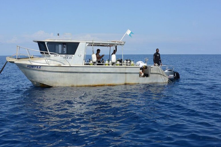 A boat in the middle of the ocean with scuba tanks.