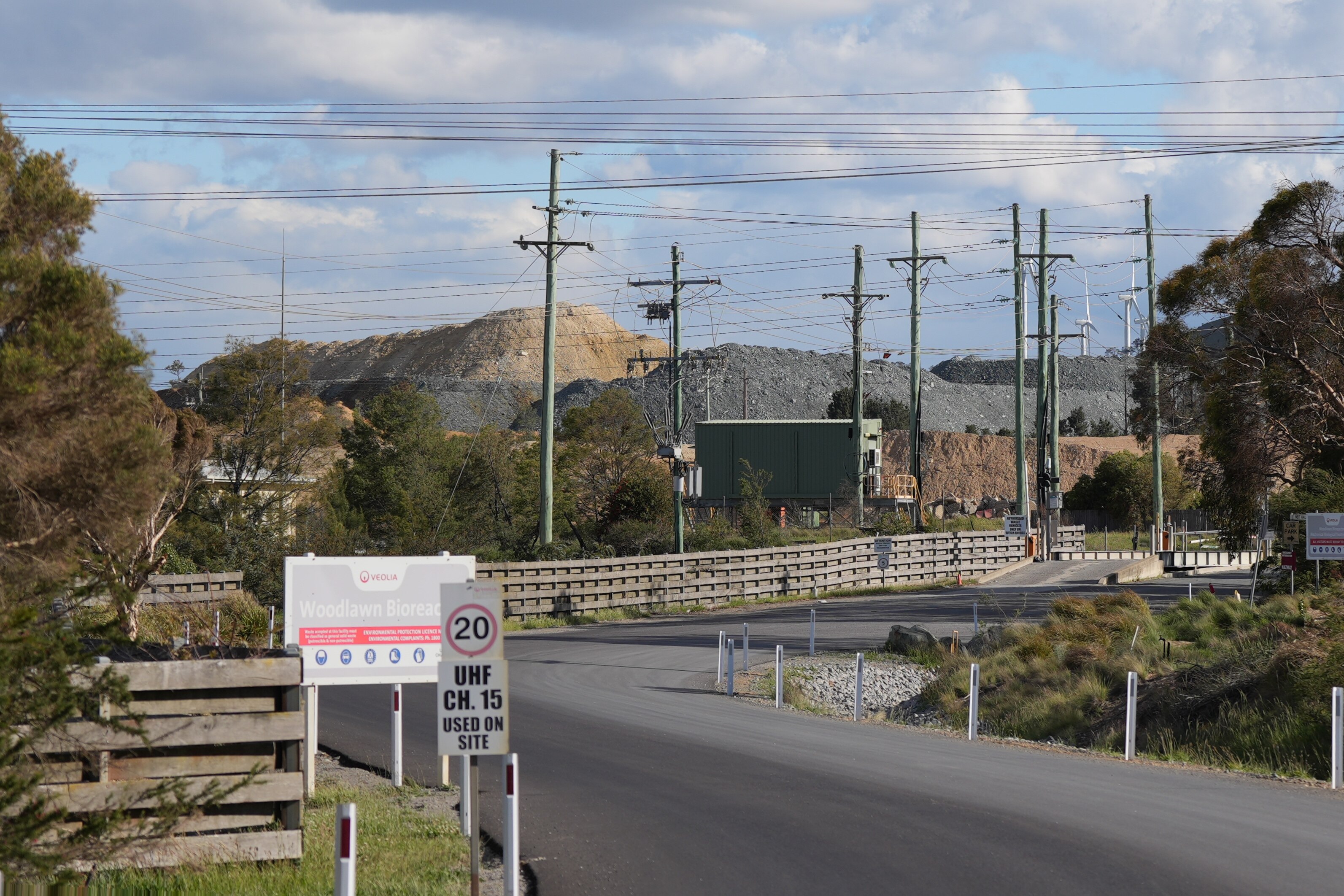 Al fondo, un cartel y un camino que conduce a una mina. 