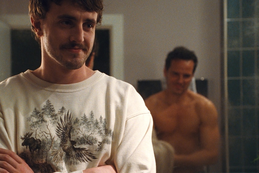  Mescal is cross-armed, watching a naked Scott (cut off at the waist) in the miror with a smile.