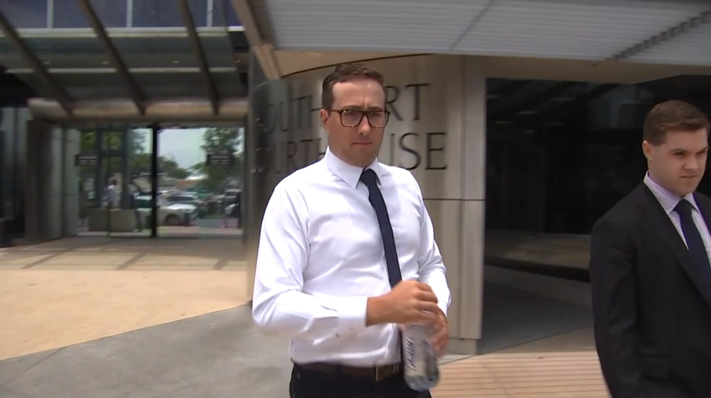 a man in a white button-up shirt and black tie walking out of a courthouse