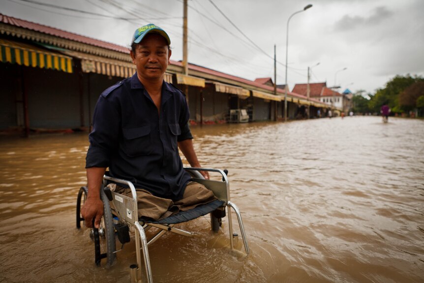 A man in a wheelchair makes his way through floodwaters in Siem Reap, September 2011.