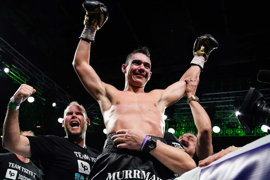 Boxer Tim Tszyu holds his gloved hands up while being carried by his team after beating Jeff Horn.