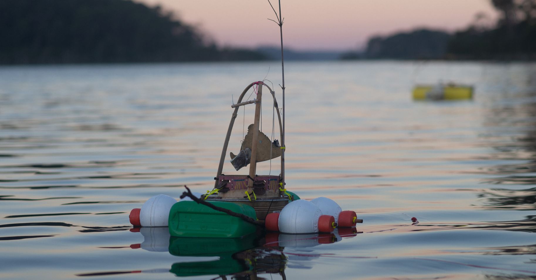 An objet d'art made of recycled material floats on a waterway.